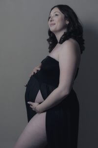 Femme enceinte en studio photo avec unerobe noire