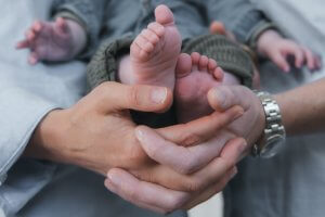 Pieds de bébé dans les mains des parents